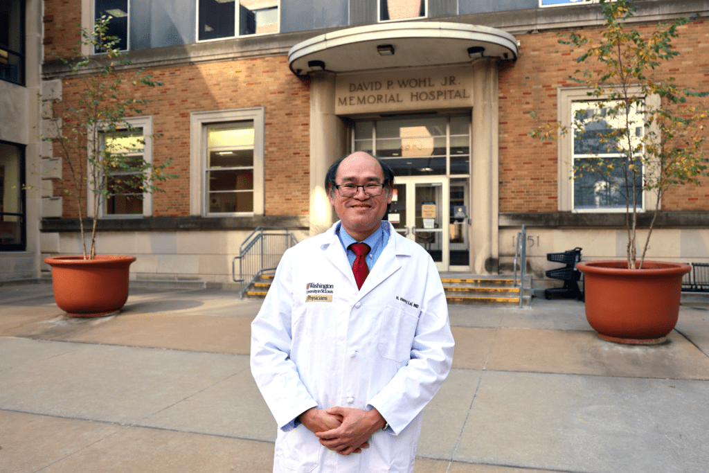 Dr. Lai in white lab coat outside Washington University School of Medicine